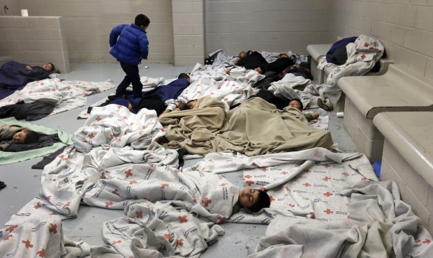 FILE – In this June 18, 2014, file photo, detainees sleep in a holding cell at a U.S. Customs...