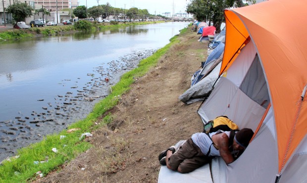 In this April 22, 2015 photo, Derek Villanueva, who is homeless, sleeps outside a friend’s te...