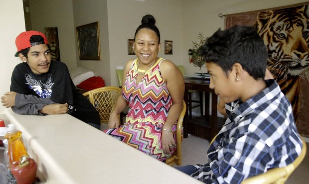 In this Thursday, July 16, 2015 photo, Mayra Rios, center, talks with her sons, Abdiel, 13, right, ...