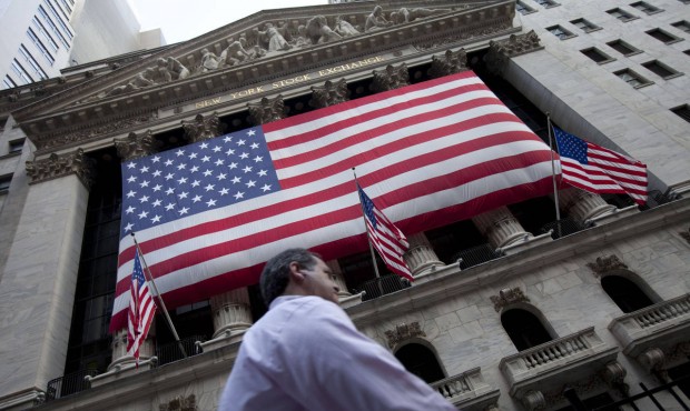 FILE – In this Monday, Aug. 8, 2011, file photo, a pedestrian walks past the New York Stock E...