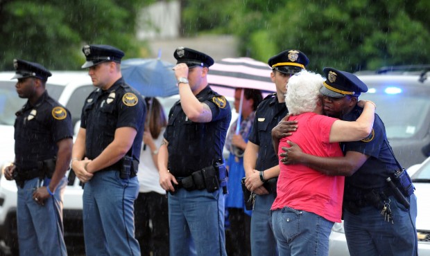 A woman hugs an officer during the procession for the body of Hattiesburg Police Officer Benjamin D...