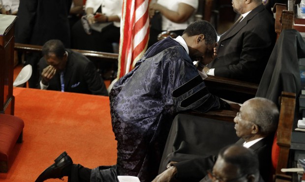 FILE – In this June 21, 2015, file photo, Rev. Norvel Goff prays at the empty seat of the Rev...
