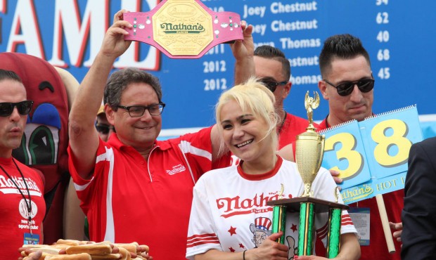 Miki Sudo, second from right, holds her trophy and smiles after winning the Nathan’s Famous F...