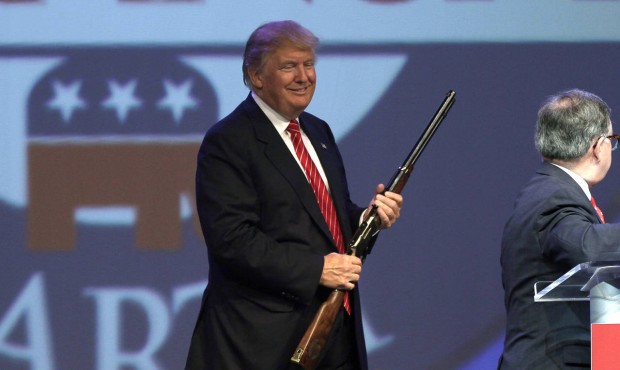 Republican presidential hopeful Donald Trump holds a Henry repeating rifle that was presented to hi...