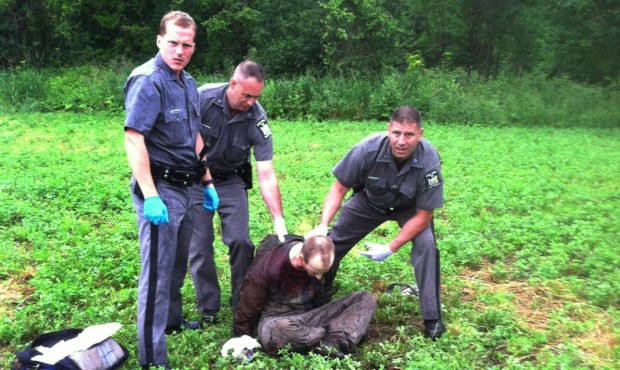 Police stand over David Sweat after he was shot and captured near the Canadian border Sunday, June ...