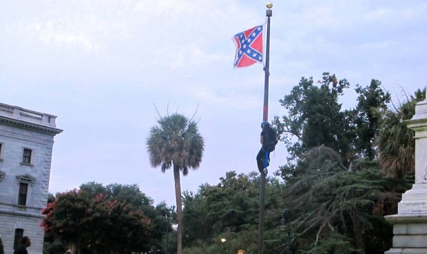 Police surround the flagpole flying the Confederate battle flag at a Confederate monument at the St...
