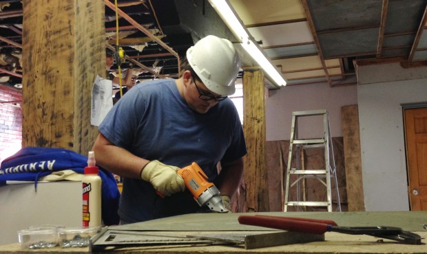 In this March 25, 2015 photo, Nathaniel Blankenship, 19, works to remodel a 1920s-era warehouse int...