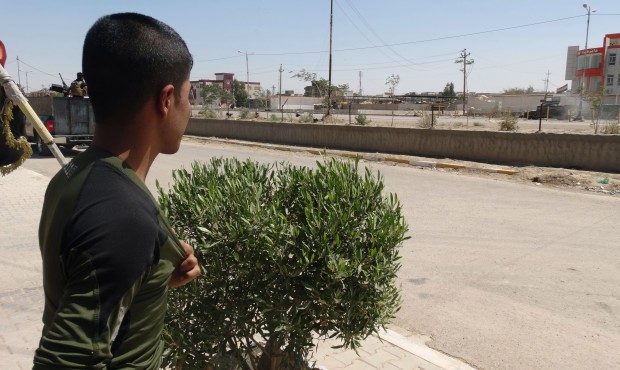 In this Sunday, May 17, 2015 photo, a boy watches Iraq security forces withdraw from Ramadi, Iraq. ...