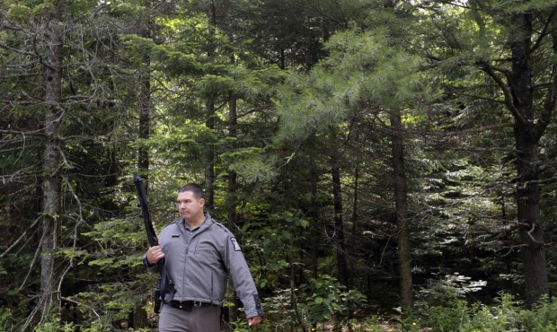A law enforcement official stands guard on Studley Road where the search for convicted murderer Dav...