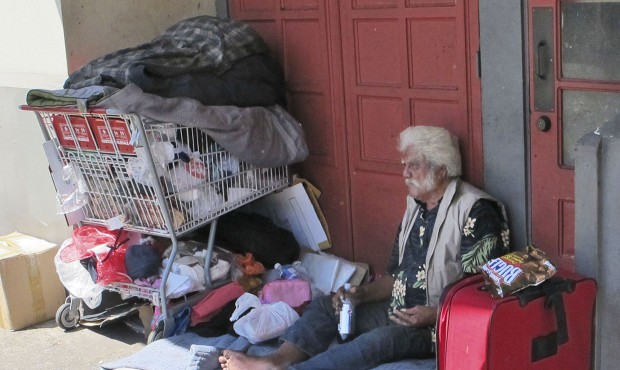 In this photo made on Tuesday, June 2, 2015, a homeless man sits on a sidewalk in Chinatown in Hono...