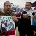 Palestinian demonstrators hold portraits of Kayla Mueller, a 26-year-old American who died while being held hostage by the Islamic State group, during a weekly demonstration against Israel's separation barrier in the West Bank village of Bilin near Ramallah, Friday, Feb. 13, 2015. Her death was confirmed this week by her family and the U.S. government, but how she died remained unclear. (AP Photo/Majdi Mohammed)