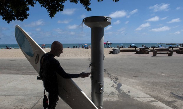 n Bob Coppola, of Laguna Niguel, uses an outdoor rinse station at Doheny State Beach in Dana Point,...