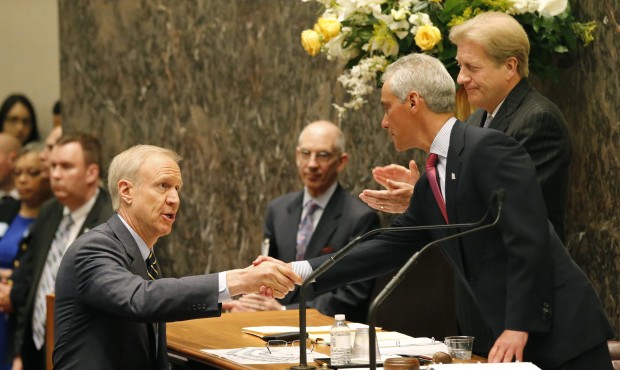 Illinois Gov. Bruce Rauner, left, shakes the hand of Chicago Mayor Rahm Emanuel, right, before Raun...