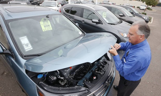 FILE – In this Dec. 2, 2014, file photo, Mike Johnson, a sales manager at a Honda car dealers...