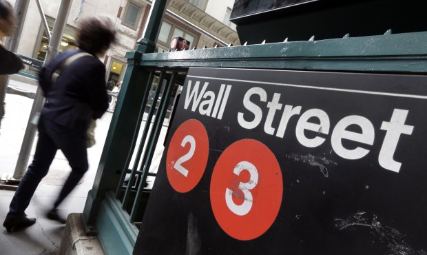 FILE – In this Oct. 2, 2014 file photo, people pass a Wall Street subway stop, in New York&#8...
