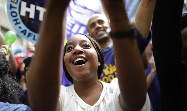 An activist cheers during a rally after the New York Wage Board endorsed a proposal to set a $15 mi...