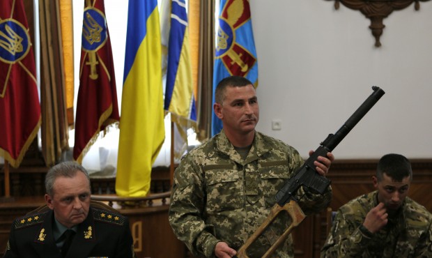 Commander of the 92nd Brigade Viktor Nikolyuk displays a rifle seized from Russian soldiers during ...