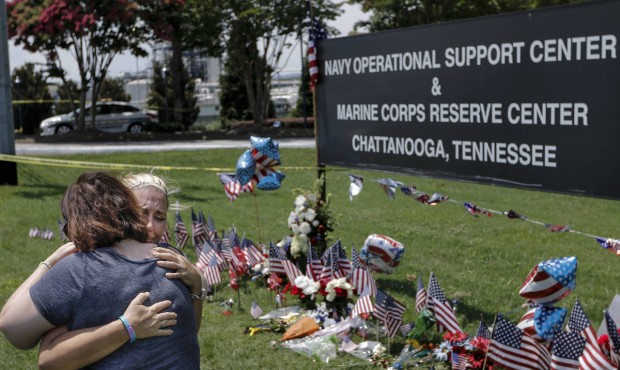 Sophia Ensley, right, and Barbie Branum embrace in front of a makeshift memorial at the Navy Operat...