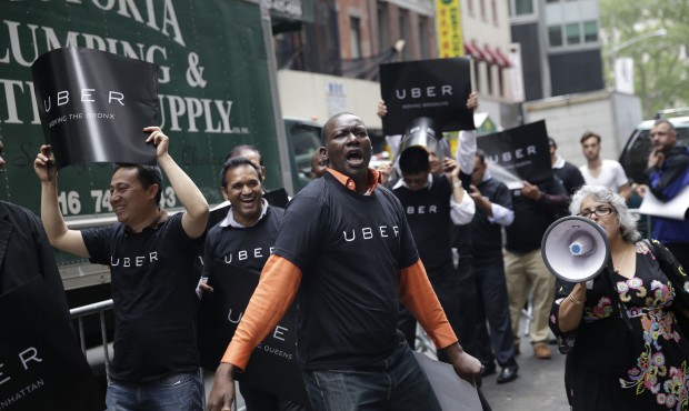 Uber drivers and their supporters protest in front of the offices of the Taxi and Limousine Commiss...