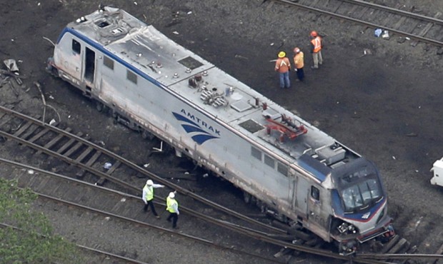 In this May 13, 2015 photo, emergency personnel work at the scene of a deadly train wreck in Philad...