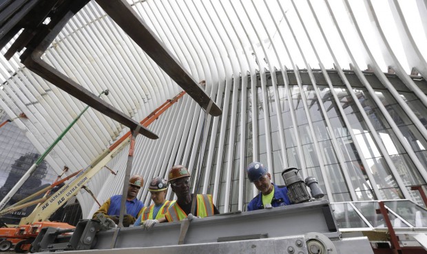 FILE – In this June 18, 2015, file photo, construction workers secure a steel apparatus to a ...