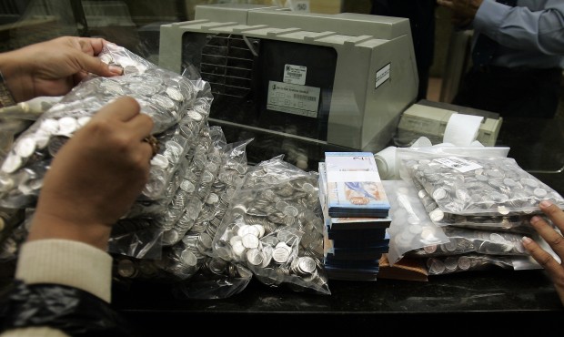 FILE – This Jan. 4, 2008 file photo shows bank workers handling Venezuela’s currency, t...