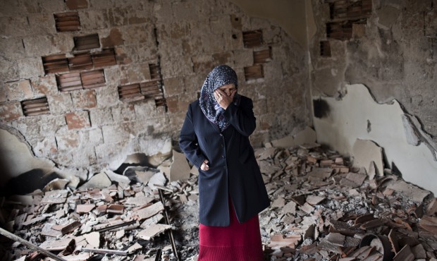 Habibe Biyali stands inside a room in her house heavily damaged by fighting in Kumanovo, Macedonia,...