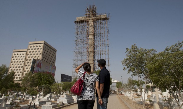 In this photo taken on Monday, May 18, 2015, a Pakistani Christian couple look at large cross, unde...