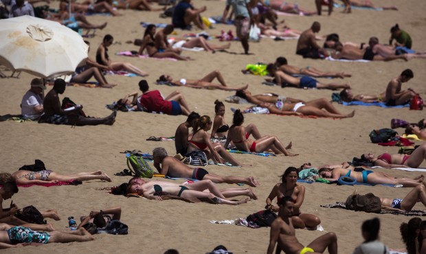 People sunbathe in a beach in Barcelona, Spain, Friday, May 15, 2015. The Iberian Peninsula has exp...