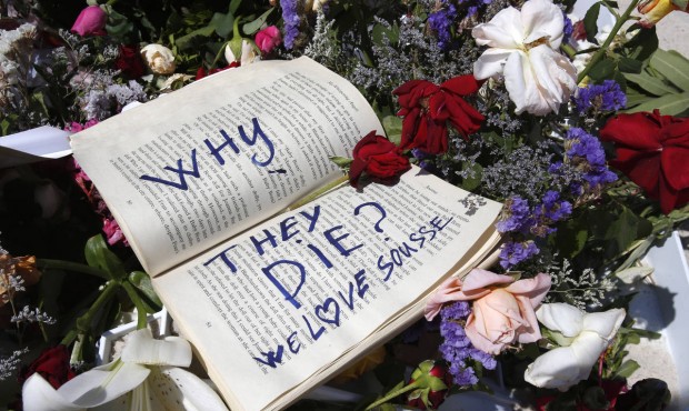 FILE – In this Sunday, June 28, 2015 file photo, a book and flowers lay at the scene of the a...