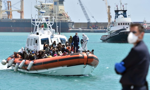 An Italian Coast Guard ship carrying migrants arrives at Pozzallo’s harbor near Ragusa, Sicil...