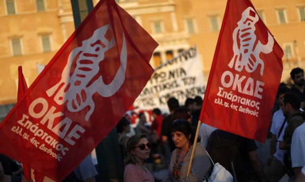 Anti-austerity protesters hold flags of their left-wing party during a rally against the government...