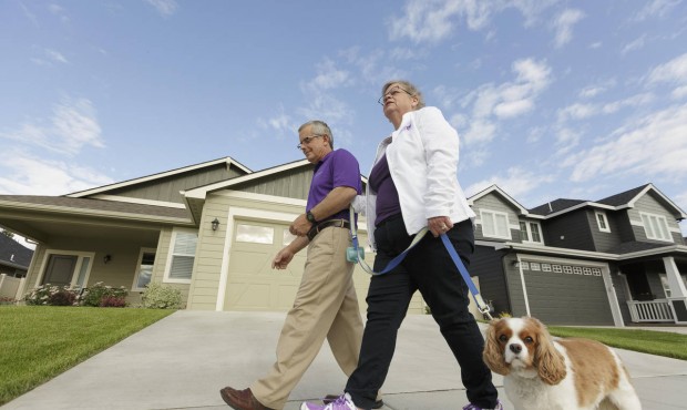 n Amy Shives, right, and her husband George walk their cavalier King Charles spaniel Chester in the...