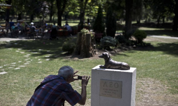 A man takes a photo of the monument to Leo, a dachshund that defended a child from an attack by ano...