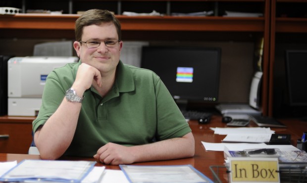 In this Wednesday, April 1, 2015 photo, Bill Lewis poses for a photograph at his desk at CMS Mailin...