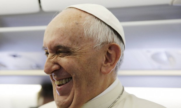 Pope Francis laughs as he meets the journalists aboard the papal airplane on the occasion of his vi...