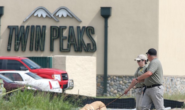 In this May 18, 2015, photo, authorities search a vacant lot near the Twin Peaks restaurant Monday,...