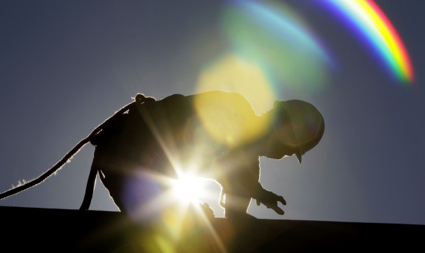 FILE – In this July 6, 2010 fik photo, a construction worker is backlit from the morning sun ...