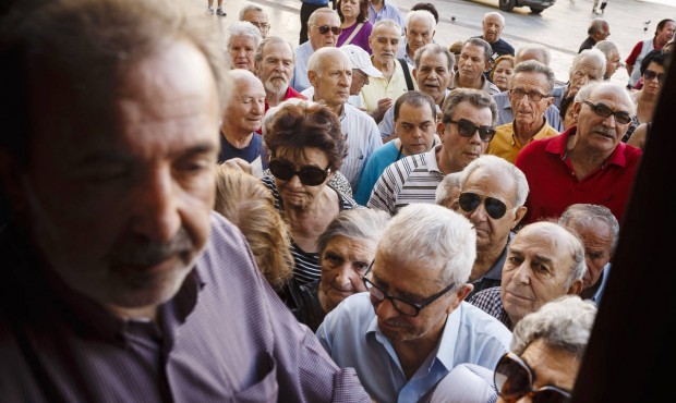 Pensioners wait to be allowed into the National Bank of Greece to withdraw a maximum of 120 euros (...