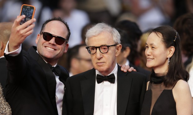An unidentified person, left, takes a selfie with director Woody Allen, center, and his wife Soon-Y...