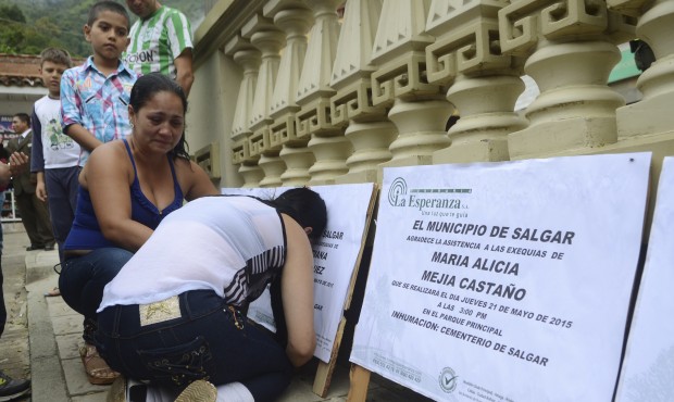 Relatives of avalanche victims mourn next to funeral signs in Salgar, in Colombia’s northwest...