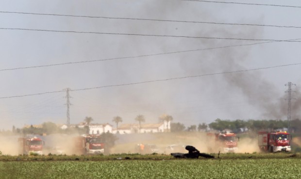 Emergency services personnel work in the area after a plane crash near Seville airport, in Spain, S...