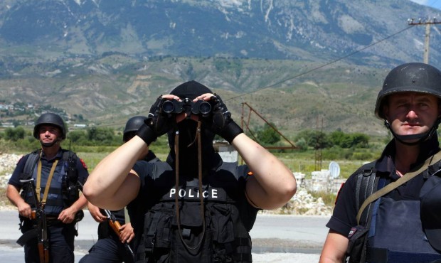 An Albanian police officer uses binoculars during an operation in Lazarat village, about 200 kilome...