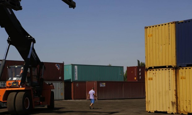 In this photo taken on Thursday, July 9, 2015 a worker walks between containers at the industrial z...