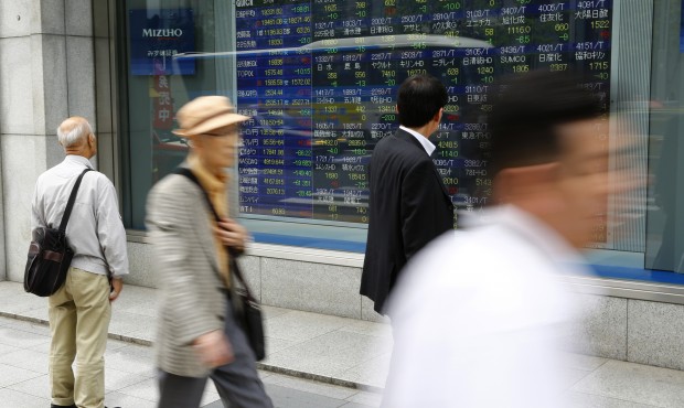 People look at an electronic stock indicator of a securities firm in Tokyo, Thursday, May 7, 2015. ...