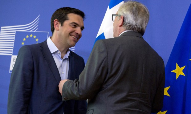 European Commission President Jean-Claude Juncker, right, speaks with Greek Prime Minister Alexis T...