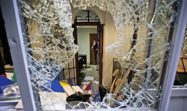 A worker inspects damage at the Thai consulate in Istanbul, Thursday, July 9, 2015. A group of prot...
