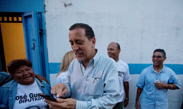 Opposition candidate Jose Guerra, center, prepares his mobile for a selfie with supporters during a...