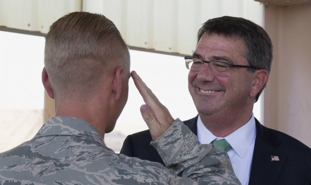 U.S. Defense Secretary Ash Carter is saluted by a member of the U.S. military as he visits and hand...