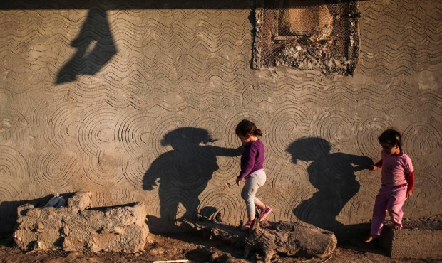 n In this Wednesday, May 6, 2015 photo, the shadows of children are cast on the wall of their home ...